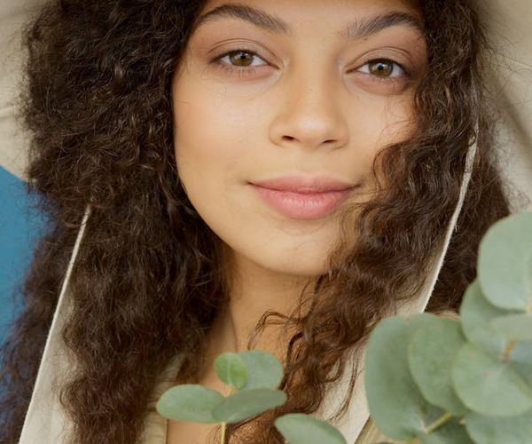 Hands holding a small green plant, symbolizing growth and care.